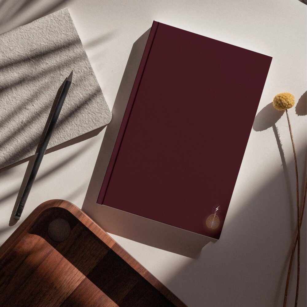 Un cahier Cornell Premium bordeaux, ouvert sur une page structurée en trois zones